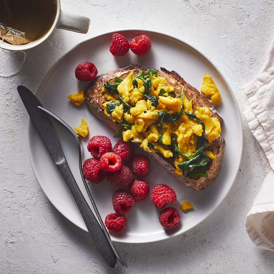 a photo of a plated Spinach & Egg Scramble with Raspberries